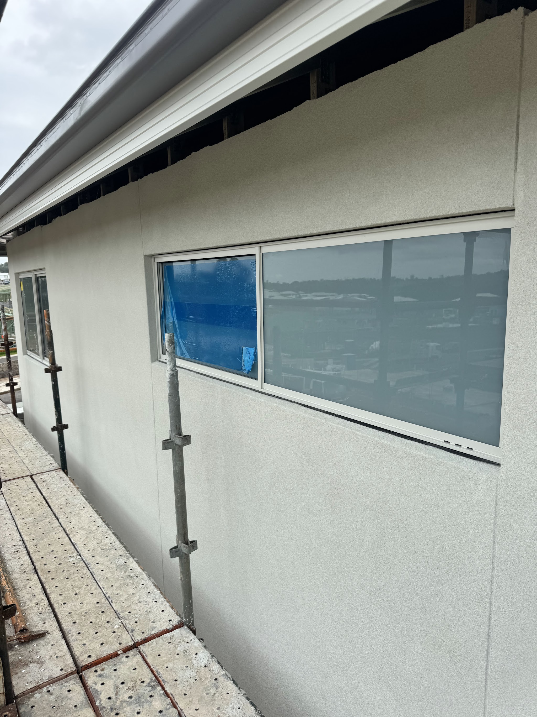 Finished smooth render wall seen from the scaffold boards